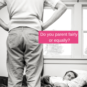 A father stands with his hands on his hips over his son who is still in bed