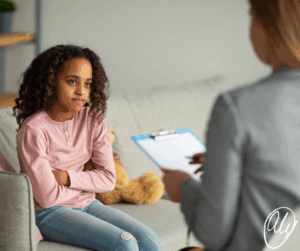 Teen sitting with therapist, looking withdrawn, showing how therapy alone isn’t helping without connection at home.
